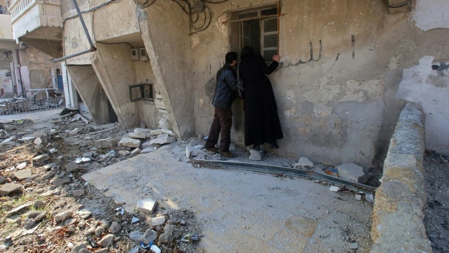 Un couple syrien devant leur maison dévastée à Alep, le 4 décembre 2016