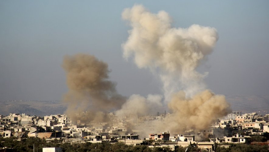De la fumée s'échappe d'immeubles et de maisons de la ville chiite pro-régime de Fuaa, dans la province d'Idlib, au nord-ouest de la Syrie, le 6 décembre 2016 à la suite de bombardements rebelles