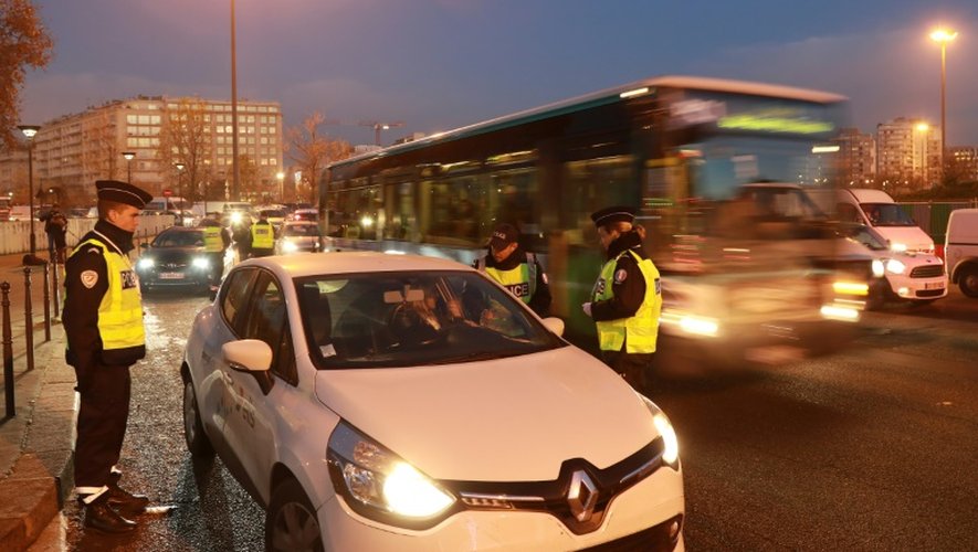 Des policiers contrôlent des véhicules le 6 décembre 2016 à Paris dans le cadre de la circulation alternée