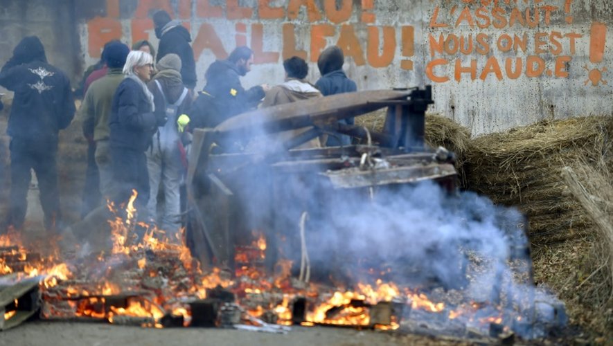 Des militants hostiles au projet d'aéroport nantais devant un slogan ciblant Bruno Retailleau, le président de la région Pays de la Loire, sur une barricade dans le territoire qu'ils occupent à Notre-Dame des Landes le 2 décembre 2016