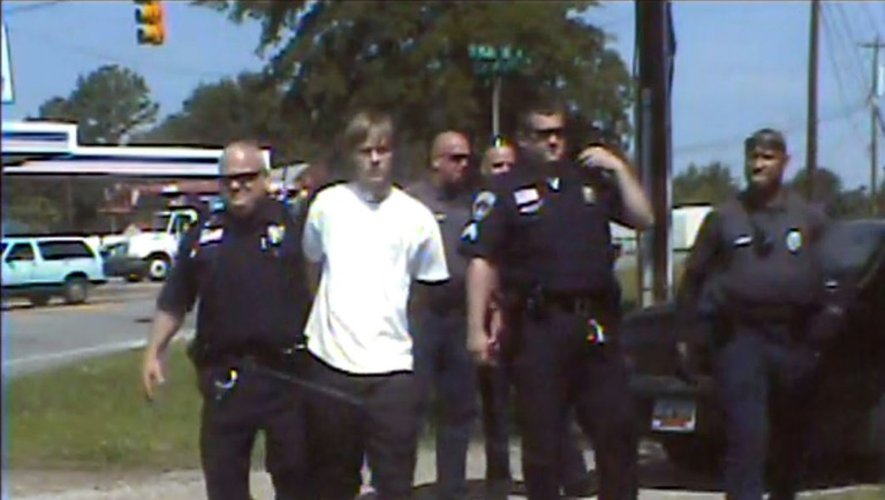 Dylann Roof (C)au milieu de policiers de Shelby (Caroline du Nord) après son arrestation, le 18 juin 2015