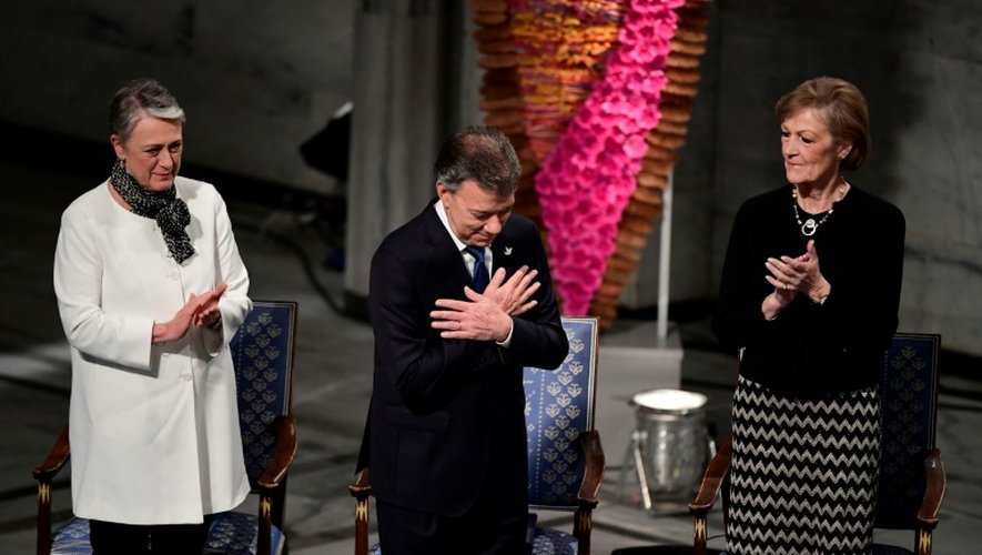 Le président de Colombie Juan Manuel Santos (c) est applaudi par des membres du comité du prix Nobel  Berit Reiss-Andersen (g) et 
Inger-Marie Ytterhorn (d) lors de la cérémonie de remise du prix, à Oslo le 10 décembre 2016