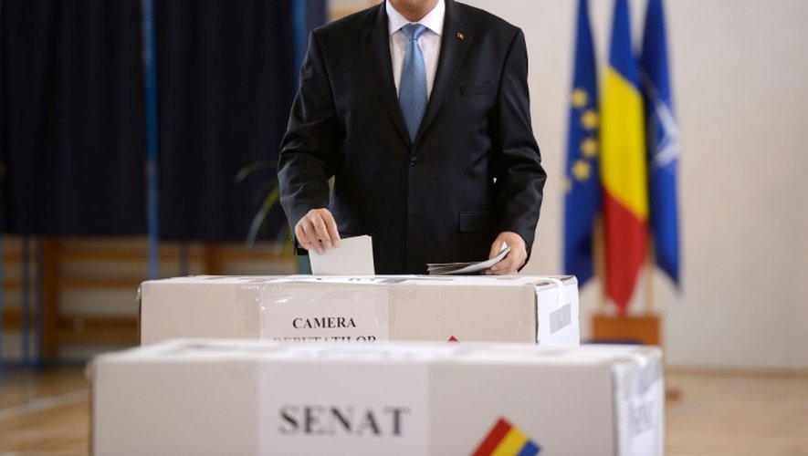Le président roumain Klaus Iohannis dépose son bulletin dans l'urne le 11 décembre 2016 dans un bureau de vote à Bucarest pour les élections législatives