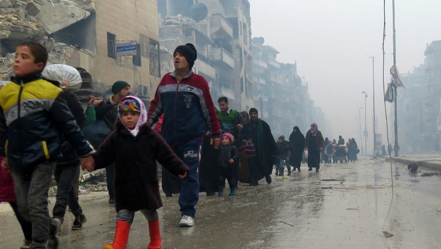 Des civils syriens quittent, sous la pluie,  le 13 décembre 2016 le quartier de Boustane al-Qasr à Alep-Est