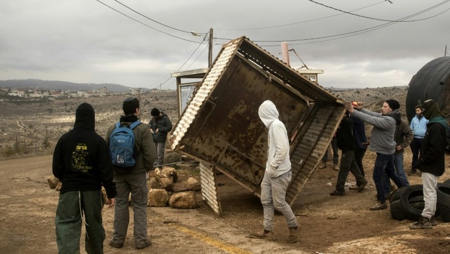 Des jeunes colons bloquent l'entrée de leur colonie Amona le 15 décembre 2016,  qui pourrait bientôt faire l'objet d'une évacuation car installée illégalement en Cisjordanie
