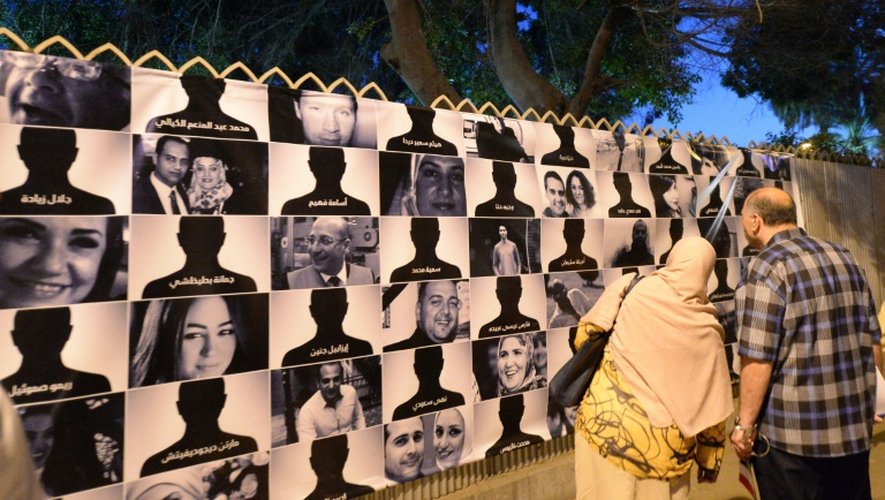 Des Egyptiens regardent le 26 mai 2016, au Caire, les portraits des 66 victimes du vol MS804 d'Egyptair qui s'est abîmé le 19 mai, entre la Crète et la côte nord de l'Égypte