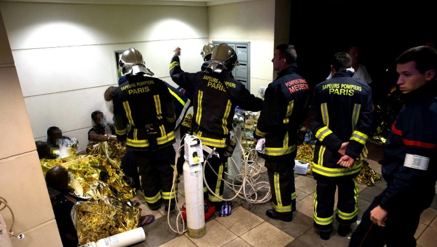 Les pompiers sur le site d'un incendie ayant touché un foyer de travailleurs immigrés, le 16 décembre 2016 à Boulogne-Billancourt près de Paris