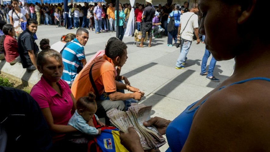 Des Vénézuéliens font la queue devant la banque centrale à Caracas pour changer leurs billets de 100 bolivars, le 16 décembre 2016