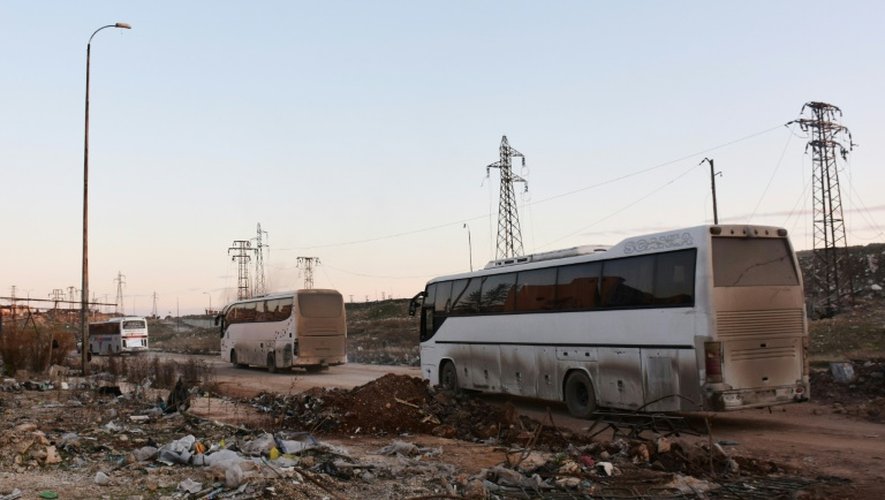 Des bus traversent  Ramoussa le 18 décembre 2016 dans la banlieue sud d'Alep