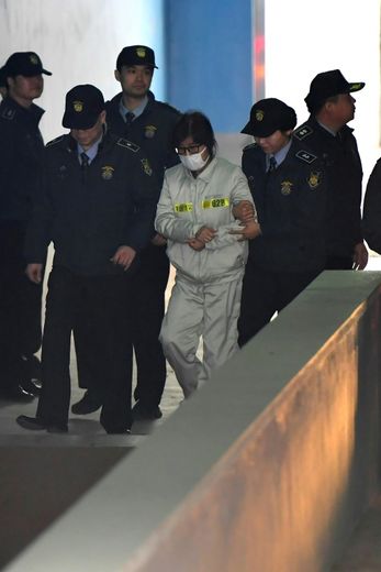 Le visage caché par un masque chirurgical et des lunettes à monture noire, Choi Soon-Sil à son arrivée le 19 décembre 2016 au tribunal à Seoul
