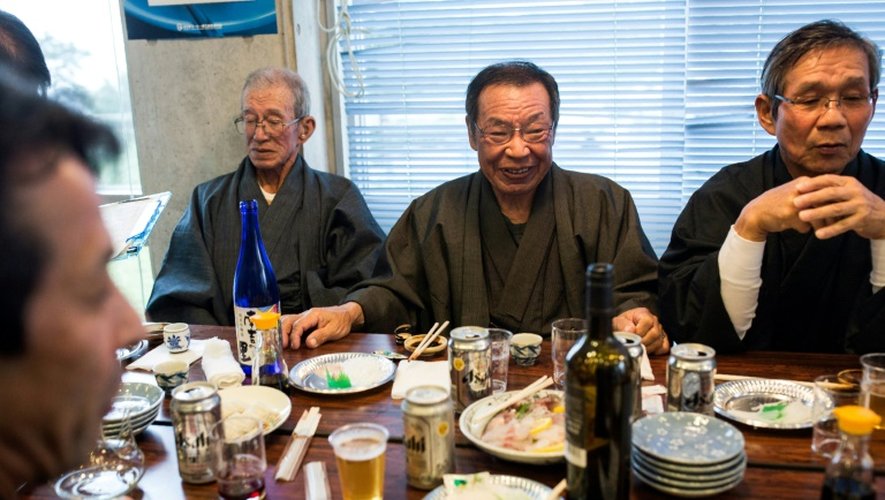 Des "chrétiens cachés" du Japon mangent après avoir chanté des prières "orasho" sur l'île Ikitsuki dans la préfecture de Nagasaki, le 23 décembre 2016