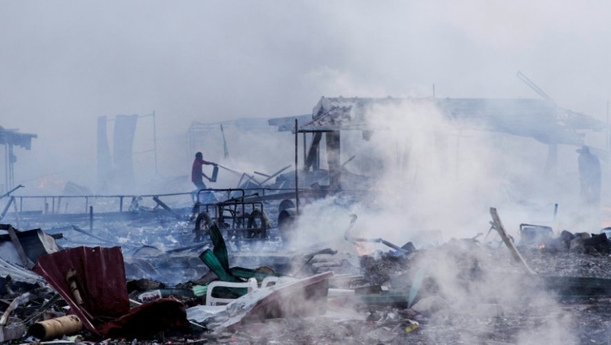 Un homme au milieu des décombres calcinés après l'explosion survenue le 20 décembre 2017 sur un marché de feux d'artifice à Tultepec, près de Mexico