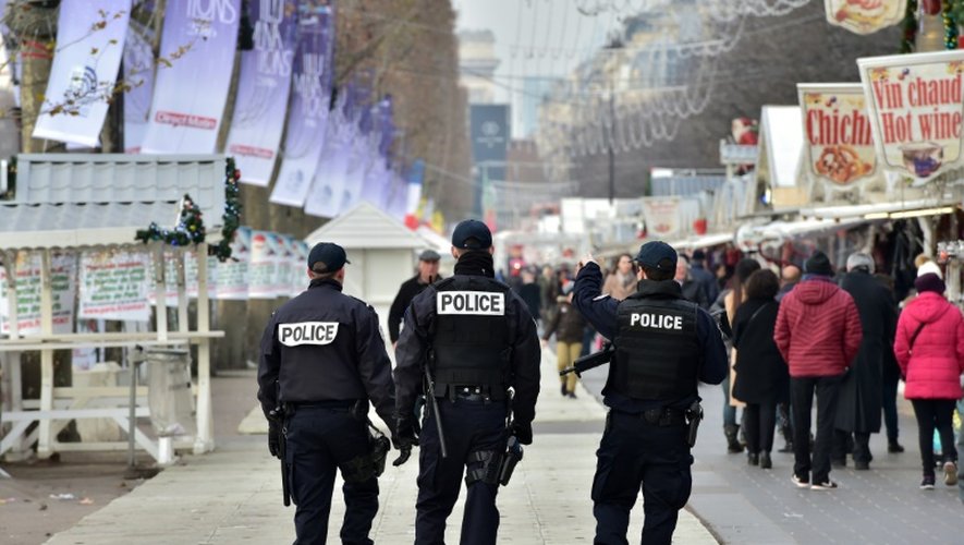 Des policiers  patrouillent le long des échoppes du marché de Noël aux Champs-Élysées à Paris, le 20 décembre 2016