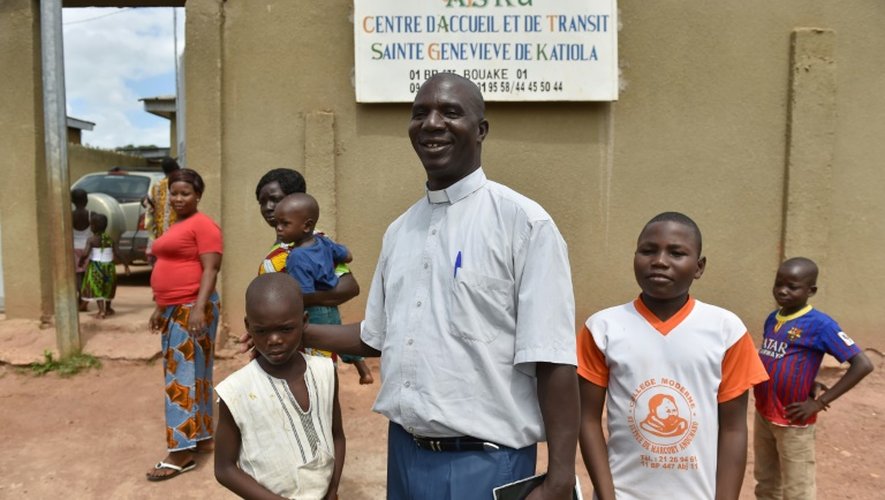 L'abbé Germain Coulibaly Kalari avec des enfants à l'entrée du "Centre d'accueil et de transit Sainte Geneviève" le 4 septembre 2016 à Katiola en Côte d'Ivoire