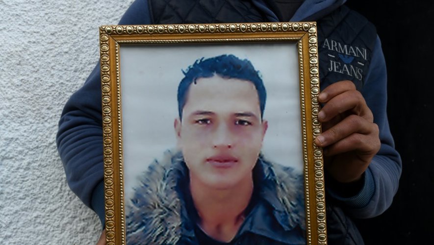 Walid Amri montre un portrait de son frère Anis Amri, suspecté de l'attaque de Berlin, à Oueslatia, en Tunisie, le 23 décembre 2016