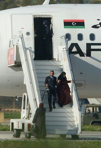 Un membre d'équipage descend de l'avion détourné avec un des otages, à l'aéroport de La Valette à Malte, le 23 décembre 2016