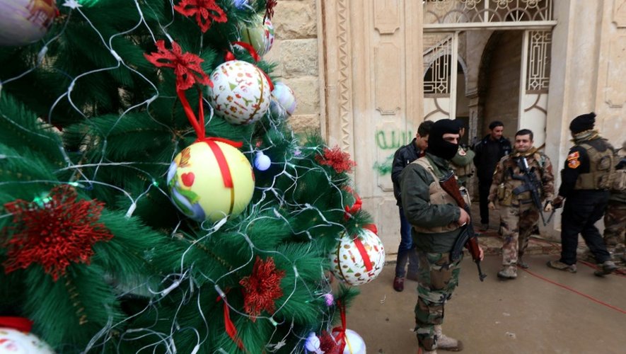 Des forces de sécurité irakiennes en faction devant l'entrée d'une église à Bartalla, près de Mossoul, le 24 décembre 2016