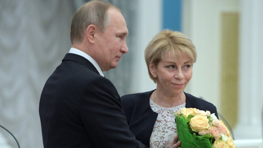 Le président russe Vladimir Poutine offre des fleurs à Elizavéta Glinka, connue du grand pubic comme "Docteur Liza", responsable d'une organisation caritative, le 8 décembre 2016 à Moscou
