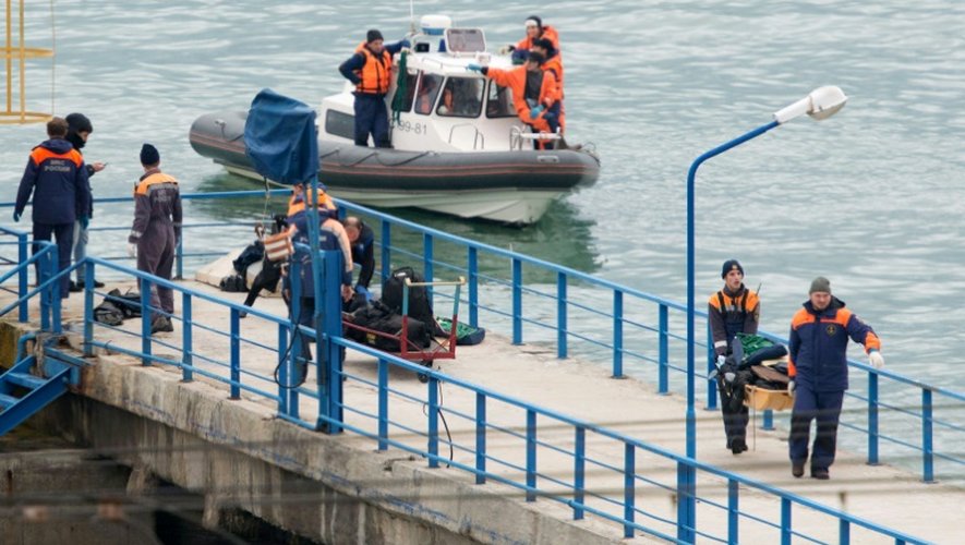 Des équipes de secours transportent, le 25 décembre 2016 à Sotchi, des bagages et effets personnels des passagers d'un avion militaire russe qui s'est abîmé en mer Noire avec 92 passagers à son bord
