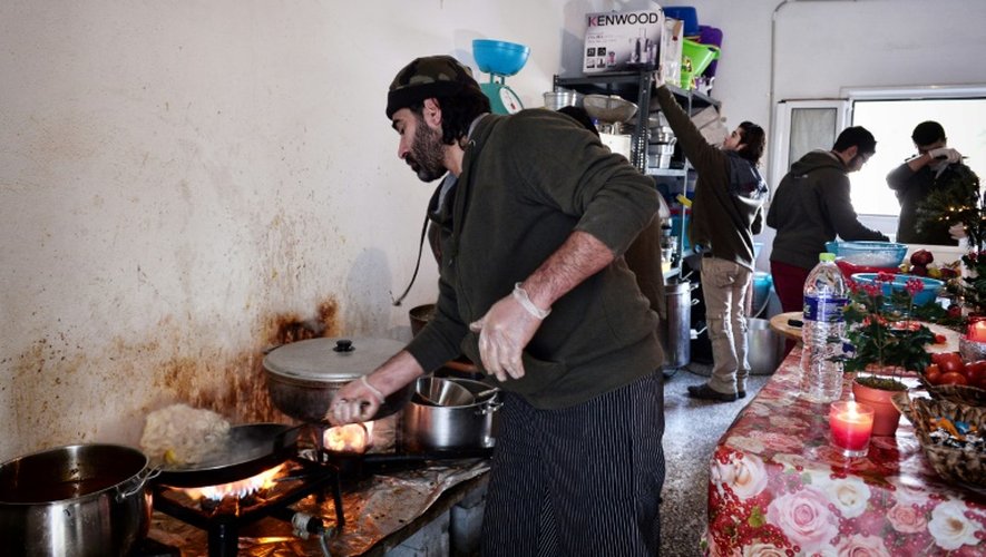 Le chef cuisinier syrien Talal Rankoussi (c) prépare un repas pour les réfugiés du camp de Ritsona, au nord d'Athènes, le 21 décembre 2016 en Grèce