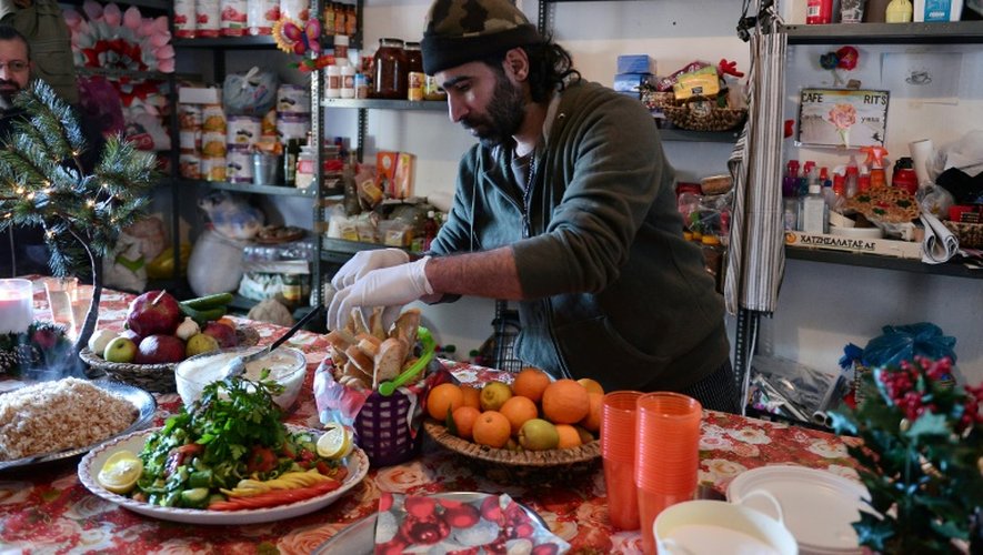 Le chef cuisinier syrien Talal Rankoussi (c) prépare un repas pour les réfugiés du camp de Ritsona, au nord d'Athènes, le 21 décembre 2016 en Grèce