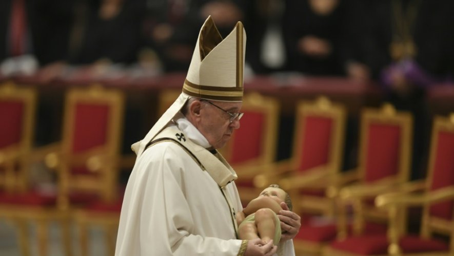 Le pape François porte une statue de l'enfant Jésus lors d'une messe à la veille de Noël, au Vatican, le 24 décembre 2016