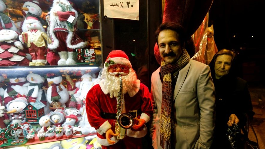 Un Iranien pose à côté d'un petit père Noël à Téhéran, le 24 décembre 2016
