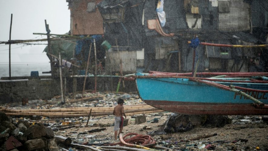 Un enfant au milieu d'une maison endommagée par le typhon Nock-Ten le 26 décembre 2016 à Manille