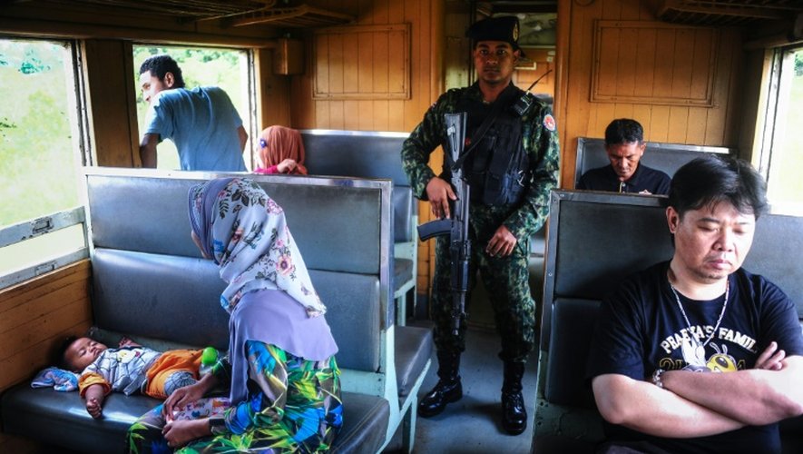 Un soldat au milieu des passagers du train de 12H33, le 21 novembre 2016 à Narathiwat dans l'extrême sud de la Thaïlande