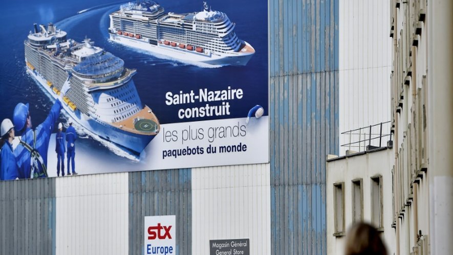 Une femme passe devant un immeuble des chantier de STX France à Saint-Nazaire le 6 décembre 2016