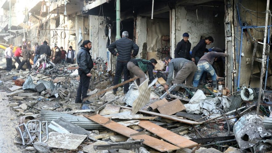 Des habitants au milieu des décombres d'immeubles après des frappes aériennes, le 4 décembre 2016 à Maaret al-Noomane, en Syrie