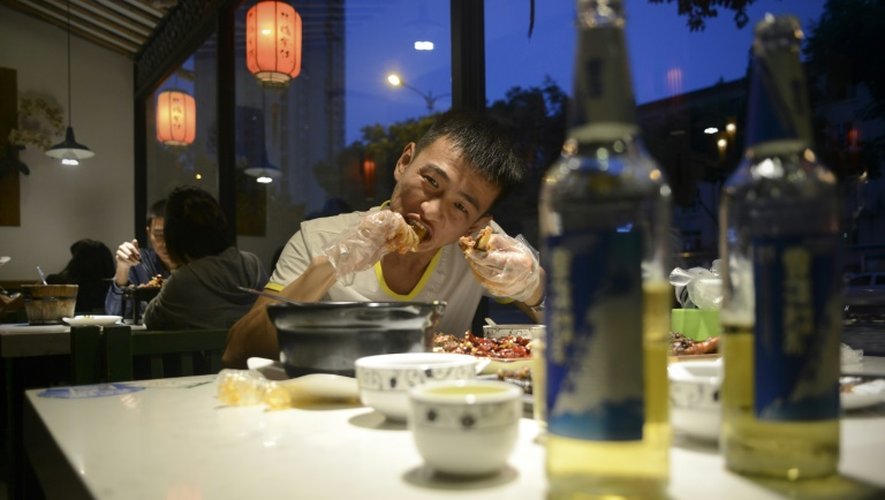 Un homme en train de manger une tête de lapin le 8 septembre 2016 dans un restaurant de Chengdu en Chine