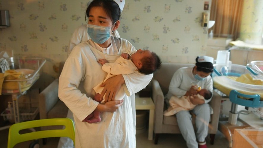 Une infimière chinoise prend soin d'un bébé, au centre Xiyuege à Pékin, le 13 décembre 2016