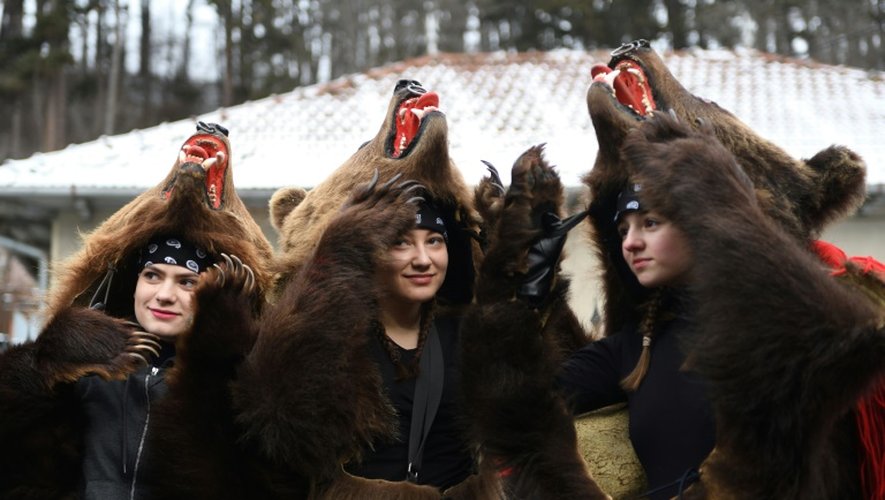 Des roumains vêtus de peaux d'ours dansent dans les rues de Comanesti, le 30 décembre 2016 lors d'un défilé pour chasser les mauvais esprits de l'année écoulée
