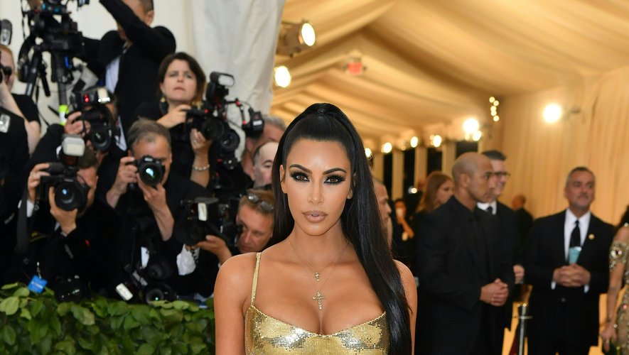 Sculpturale, Kim Kardashian a foulé le tapis rouge dans une robe moulante or métallisé signée Atelier Versace. Le tout accessoirisé avec un collier doté d'un pendentif en forme de croix. New York, le 7 mai 2018.