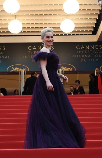 L'actrice Emilia Clarke choisit elle aussi de dénuder ses épaules dans une élégante robe de bal en tulle pourpre Dior Haute Couture. Cannes, le 15 mai 2018.
