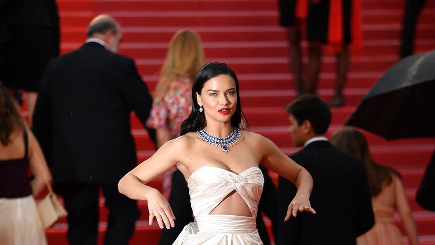 L'Ange de Victoria's Secret a foulé le tapis rouge cannois dans une robe bustier drapée en satin de soie blanc avec de nombreuses découpes, signée Alberta Ferretti. Cannes, le 16 mai 2018.