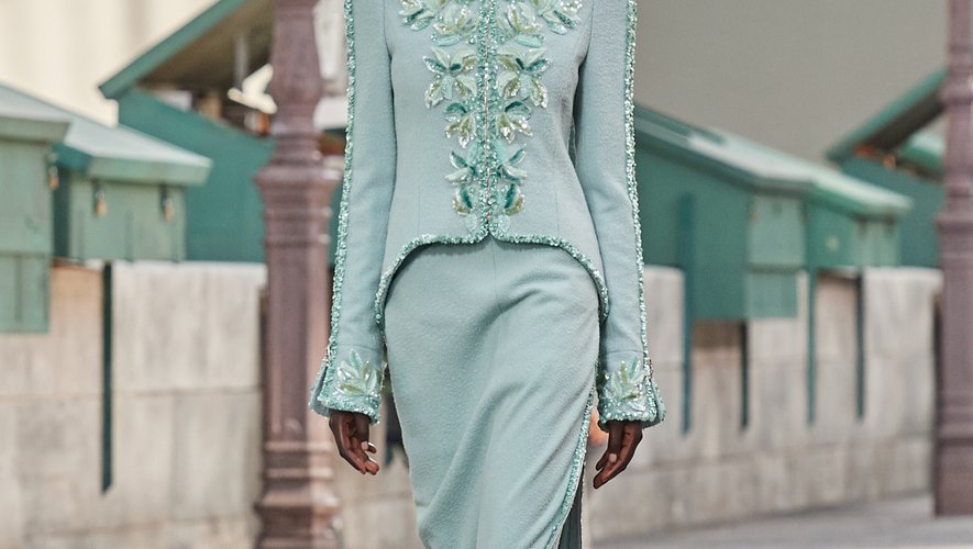 La maison Chanel se distingue avec une robe de mariée droite, légèrement fendue, en tweed vert pâle. Le tout accompagné d'une veste type redingote rebrodée de feuilles.