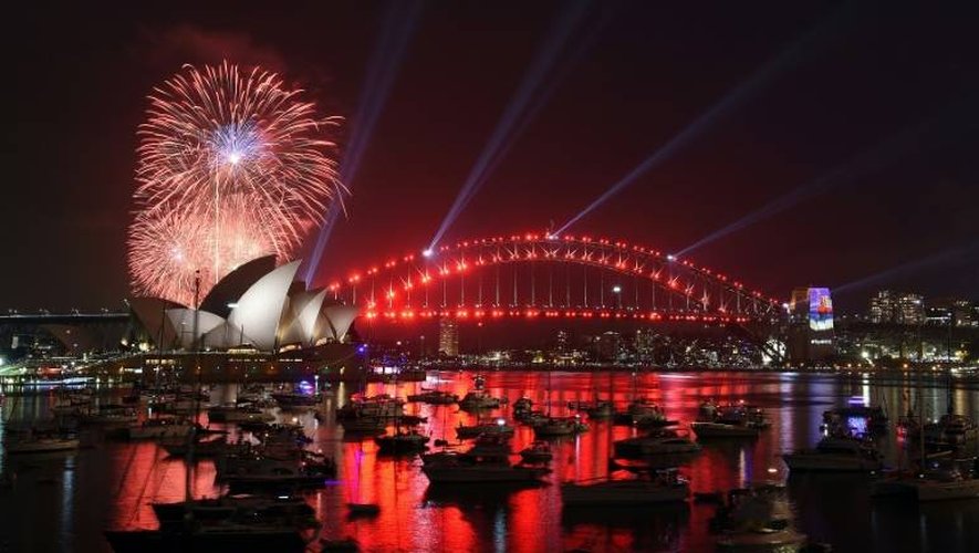 Des feux d'artifice familiaux illuminent le ciel au-dessus de l'Opéra de Sydney en Australie, avant le feu d'artifice officiel, le 31 décembre 2016