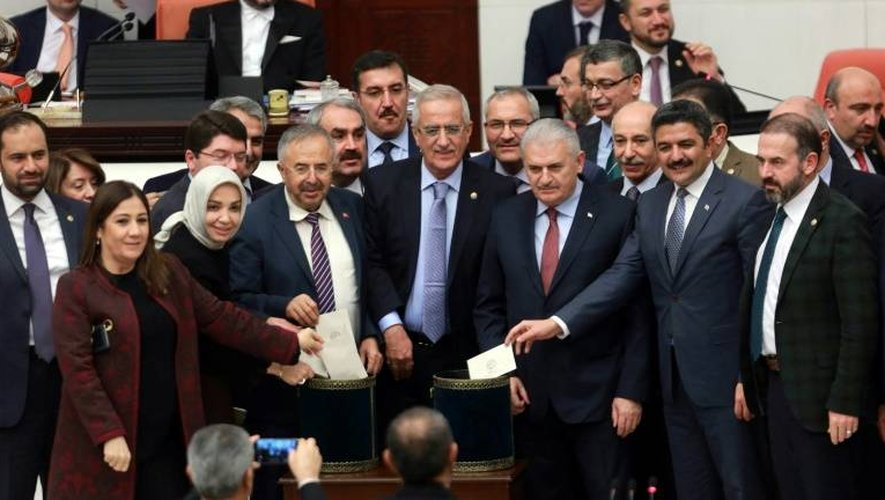 Le Premier ministre turc, Binali Yildirim (3eD) et des parlementaires posent avant de glisser leur bulletin dans l'urne lors du vote prévoyant un changement dans la constitution, au parlement à Ankara, le 14 janvier 2017.