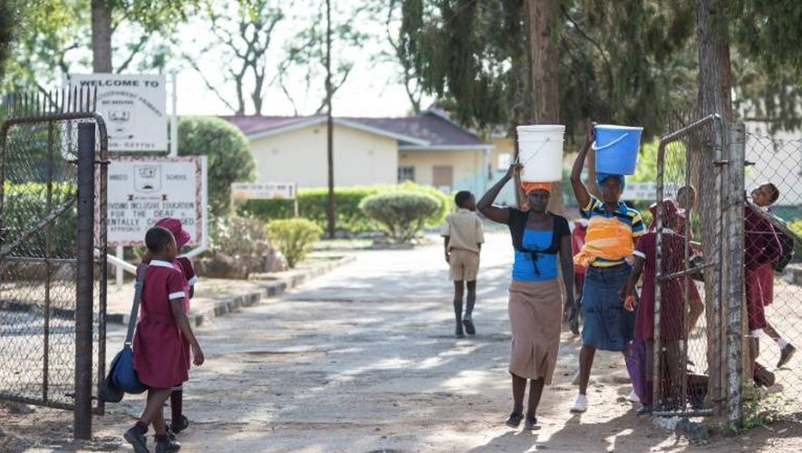 Des femmes avec des seaux d'eau sur leur tête le 24 novembre 2016 à Bulawayo