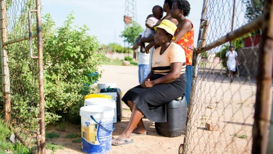 Des femmes font la queue pour remplir leur sceau d'eau dans un quartier périphérique de Wulawayo le 24 novembre 2016