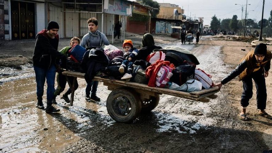 Des Irakiens fuient leurs habitations et sortent leurs effets personnels dans les rues de Mossoul, lors d'une opération militaire, le 8 janvier 2017