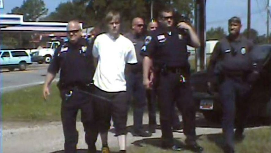 Dylann Roof, en blanc, au milieu de policiers de Shelby en Caroline du Nord après son arrestation, le 18 juin 2015