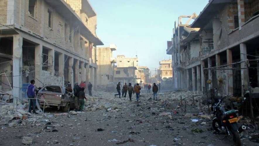 Des Syriens courent après des raids aériens dans la ville de Binnish, dans les environs d'Idleb le 12 janvier 2017