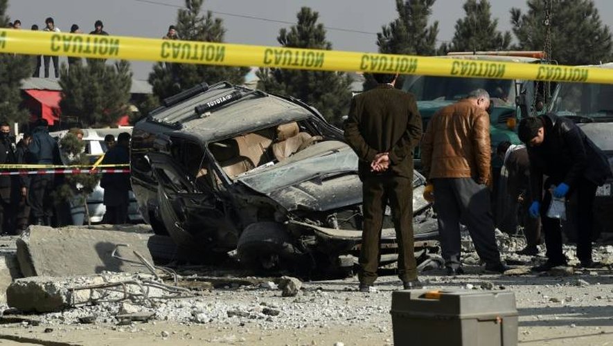 Des forces de sécurité afghanes inspectent le site d'une explosion à la voiture piégée, le 28 décembre 2016 à Kaboul