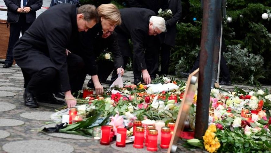 Le maire de Berlin Michael Mueller, la chancelière Angela Merkel, et les ministres Thomas de Maiziere et Frank-Walter Steinmeier rendent hommage aux victimes de l'attentat le 20 décembre 2016 devant le marché de Noël de Berlin