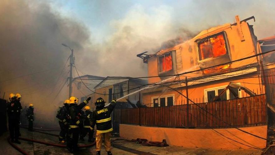 Des pompiers éteignent un incendie le 2 janvier 2017 à Valpareiso (Chili)