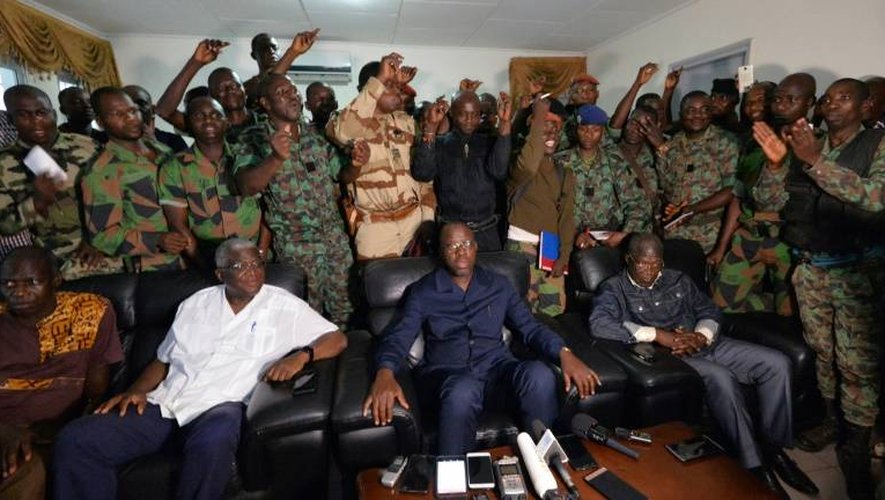 Une délégation de soldats rebelles se tiennent derrière le ministre ivoirien de la Défense Alain Richard Donwahi (C) après des négociations, le 7 janvier 2017 à Bouaké