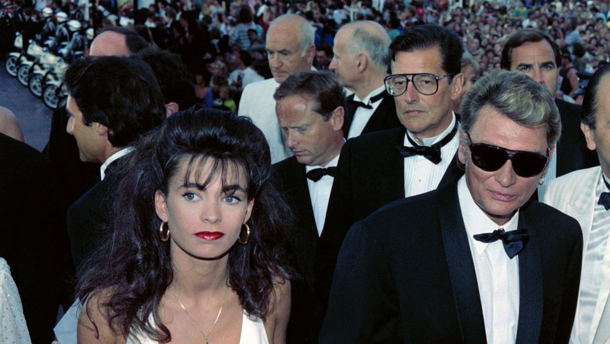 Le chanteur Johnny Hallyday arrive le 10 mai 1990 au festival de cinéma à Cannes en compagnie de sa fiancée, Adeline Blondieau.